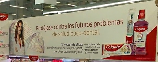 instalación PLV Colgate en supermercado con cabecera de marca y mobiliario Retail