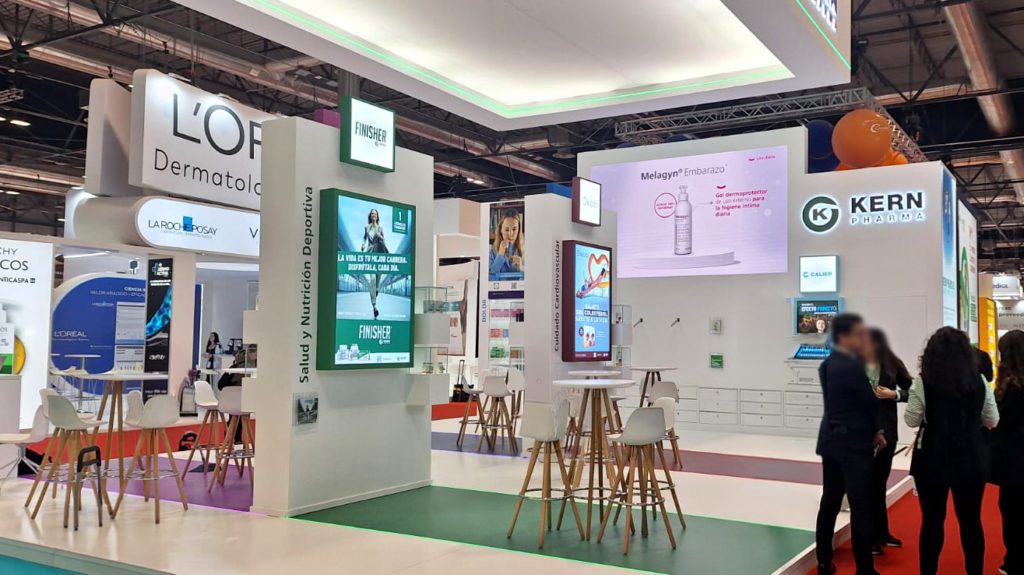 Vista general del stand de Kern Pharma en Infarma con zonas de reunión y señalética vertical